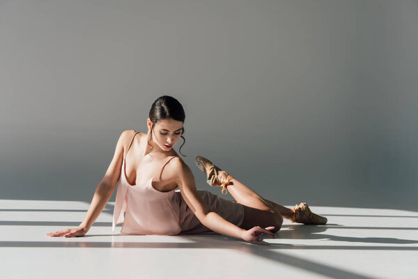 beautiful ballerina dancing in pink dress and pointe shoes 