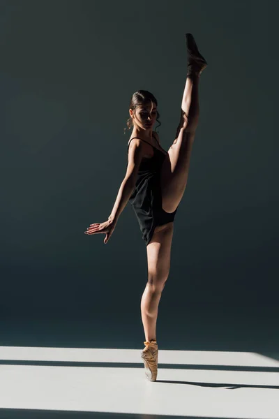 优雅的年轻芭蕾舞演员穿着黑色礼服在阳光下跳舞 — 图库照片