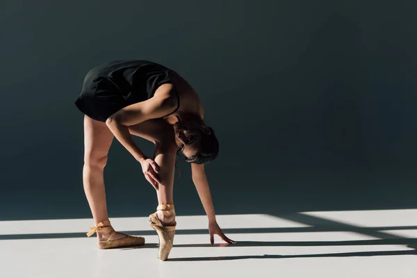 美丽的年轻芭蕾舞演员伸展在黑色礼服 — 图库照片