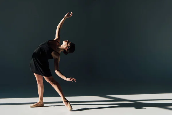 黒のドレスとポワント シューズで踊る魅力的なバレリーナ — ストック写真