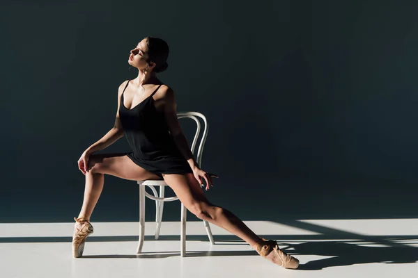 Prachtige Ballerina Zwarte Jurk Die Zich Uitstrekt Witte Stoel — Stockfoto