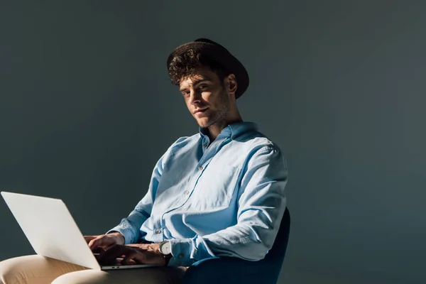 Schöner Mann Sitzt Mit Laptop Sonnenlicht Und Schaut Die Kamera — Stockfoto