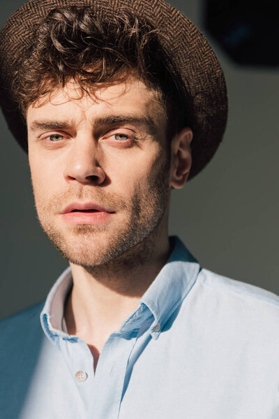 portrait of handsome man in blue shirt and brown hat 