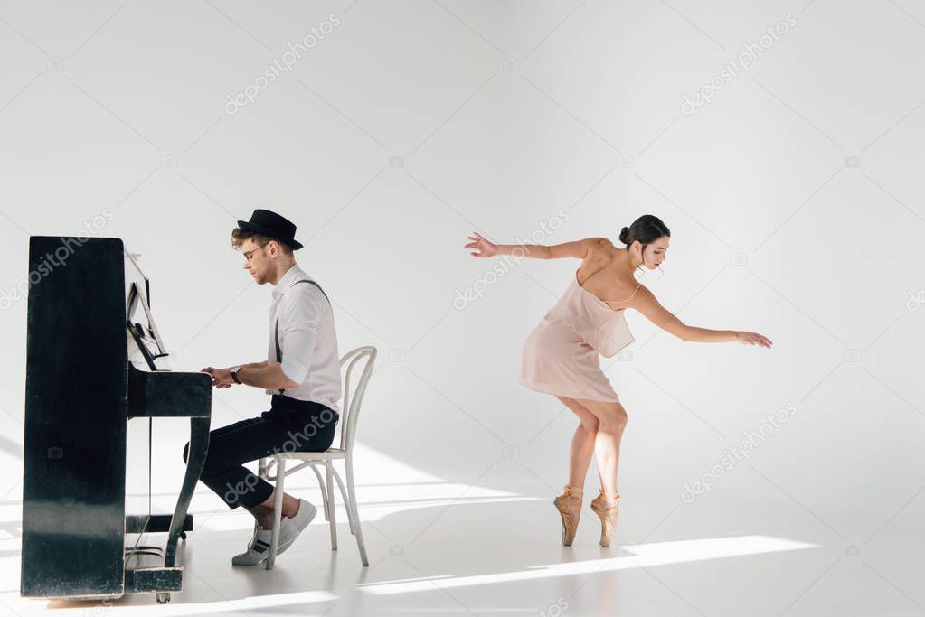 beautiful ballerina in pink dress dancing while handsome pianist playing piano 