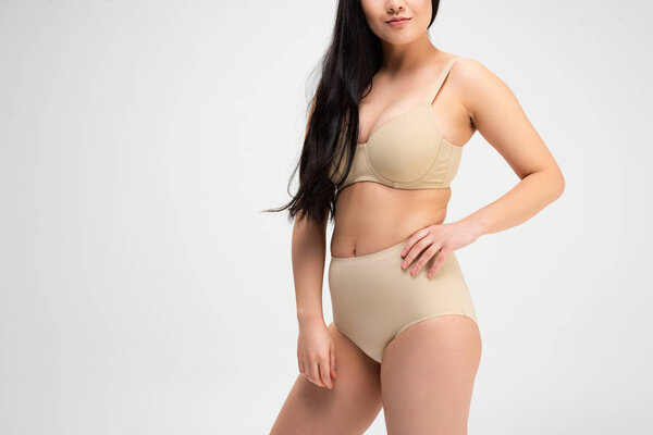 cropped view of girl in underwear with hand on hip isolated on grey, body positivity concept