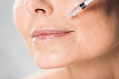 seçici odak kapalı gözler güzellik enjeksiyon gri izole getting ile güzel ve Olgun kadın