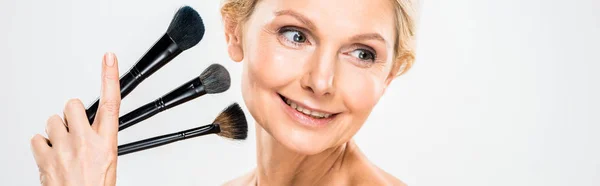 Panoramy Pięknym Blondynka Starsza Kobieta Szukasz Drogi Trzymając Pędzle Kosmetyczne — Zdjęcie stockowe