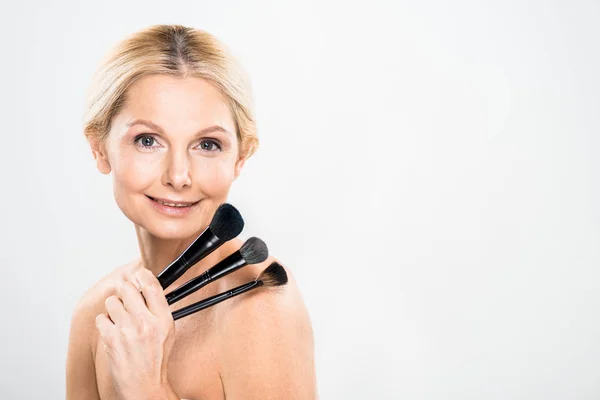 Beautiful Blonde Mature Woman Looking Camera Holding Cosmetic Brushes Grey — Stock Photo, Image