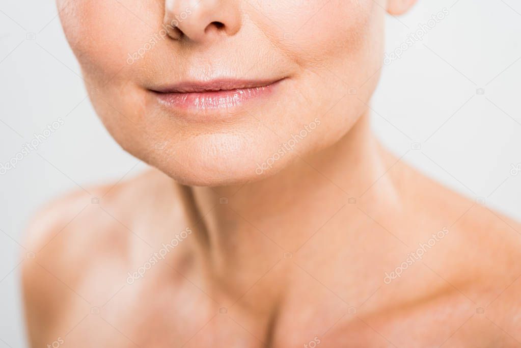 selective focus of mature woman isolated on grey with copy space 