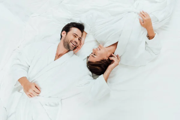 Ovanifrån Lyckliga Paret Badrockar Tittar Varandra Liggande Sängen — Stockfoto