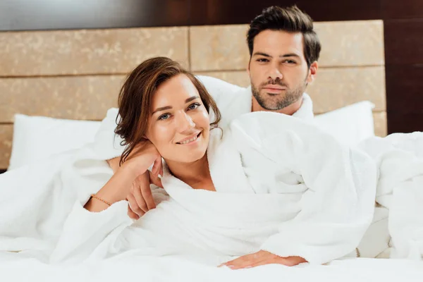 Handsome Man Happy Girlfriend White Bathrobes Looking Camera While Lying — Stock Photo, Image