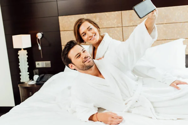 Glada Par Tar Selfie Smartphone Liggande Sängen — Stockfoto