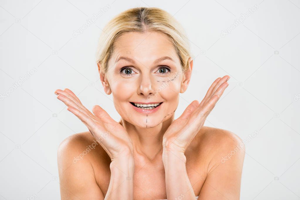 beautiful and surprised woman with lines on face looking at camera and showing shrug gesture isolated on white