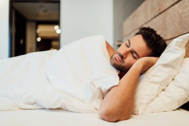 yatakta uyuyan yakışıklı sakallı adamın seçici odak 