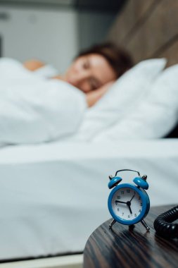 retro mavi çalar saat yatakta uyuyan kadın yakınındaki seçici odak