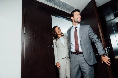 neşeli sakallı adam ve çekici kadın resmi girerek otel odasında giymek 