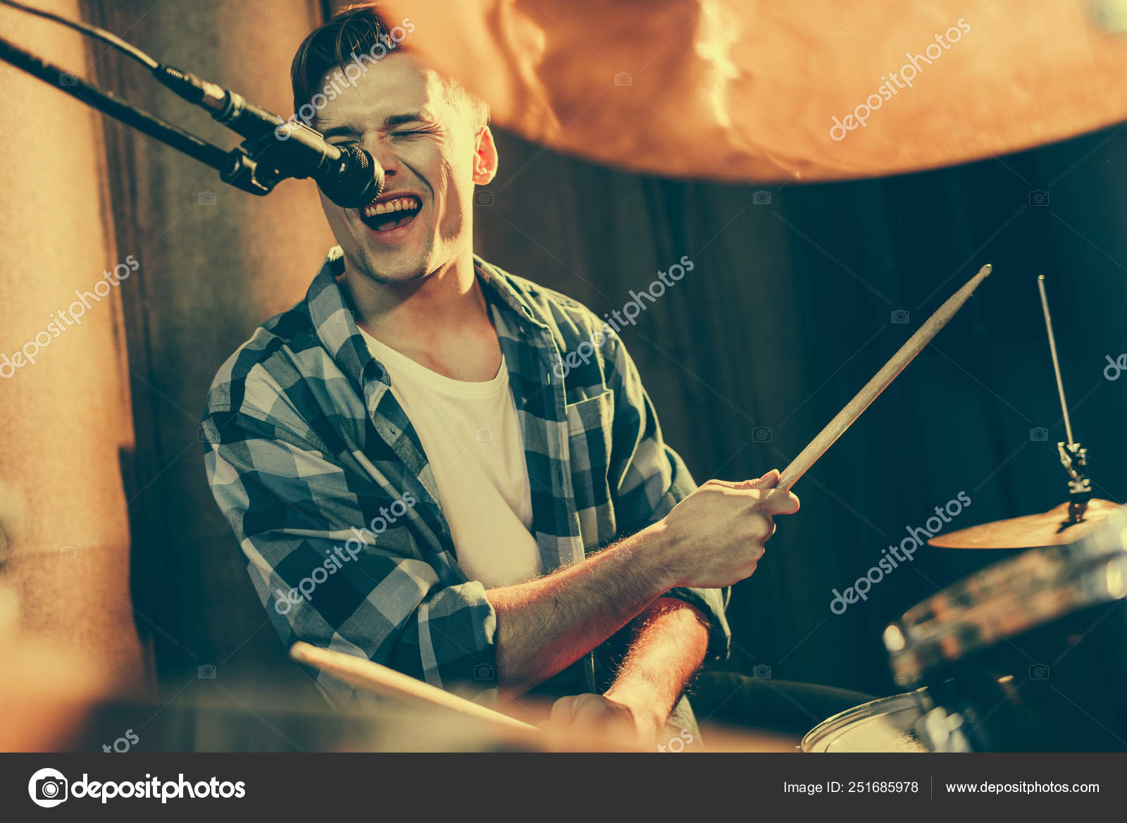 Selective Focus Handsome Man Singing Microphone While Playing Drums