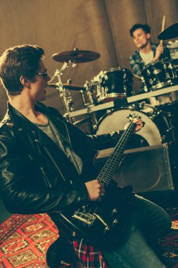 seçici odak Izgaralı gitar gitarist davulcu oynarken elinde 