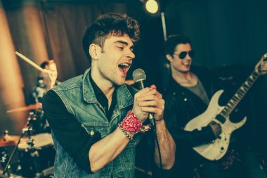 seçici odak neşeli adam mikrofon rock grubu yakınındaki şarkı 