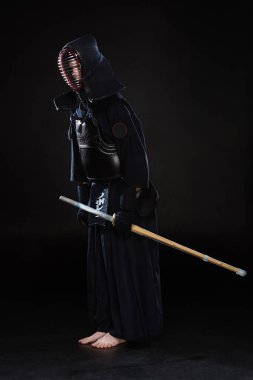 Kendo Fighter siyah üzerine eğilerek kılıç ile tam boy görünüm