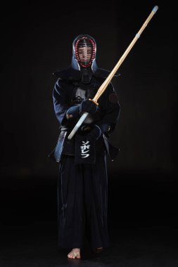 Tam boy görünüm kendo Fighter bambu kılıcı tutan siyah kask içinde