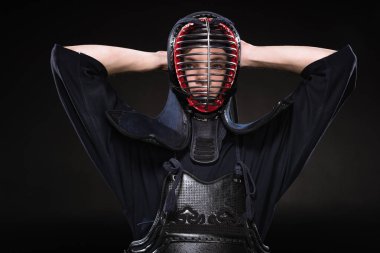 Kendo savaşçı kask dokunmaktan ve siyahta kameraya bakarak zırh