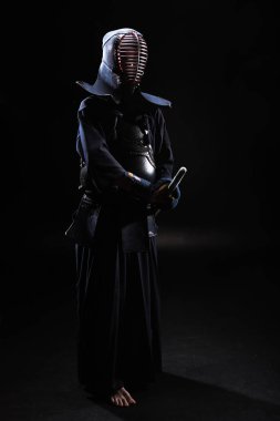 Tam boy görünüm kendo Fighter bambu kılıcı tutan siyah kask içinde