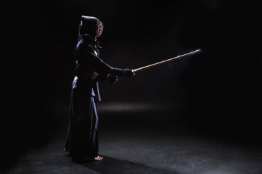 Kendo savaşçı zırh siyah bambu kılıçla pratik yan görünüm