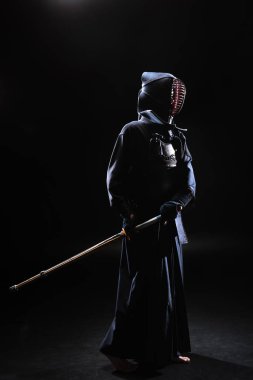Tam boy görünüm kendo Fighter bambu kılıcı tutan siyah kask içinde