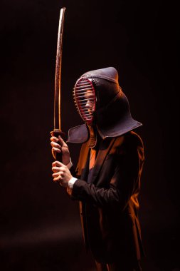 Kendo savaşçı formal giyim ve karanlık bambu kılıcı tutan kask