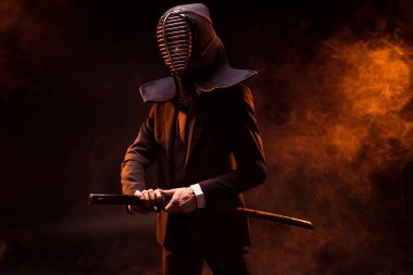 Kendo savaşçı formal giyim ve karanlık bambu kılıcı tutan kask
