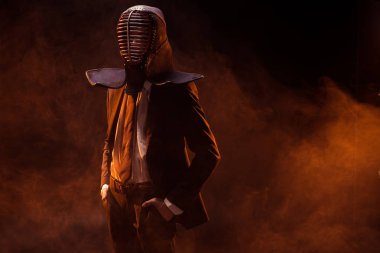 Ceplerinde kara günü resmi giyim ve kendo kask ile ayakta içinde kendine güvenen adam eller
