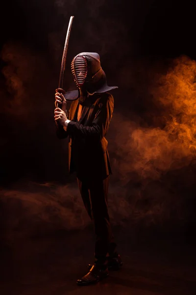 在正式的服装和头盔在黑暗中拿着竹剑的剑的完整视野 — 图库照片