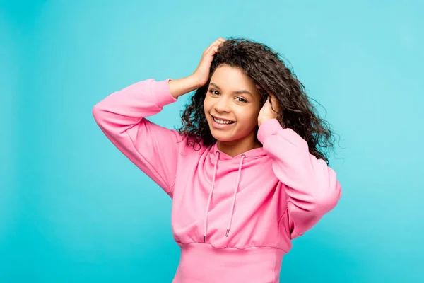 Smiling Curly African American Woman Touching Hair Isolated Blue — Stock Photo, Image