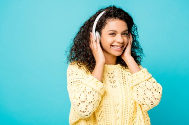 mavi üzerinde izole kulaklıklar mutlu kıvırcık Afrikalı Amerikan Kız dinleme müzik