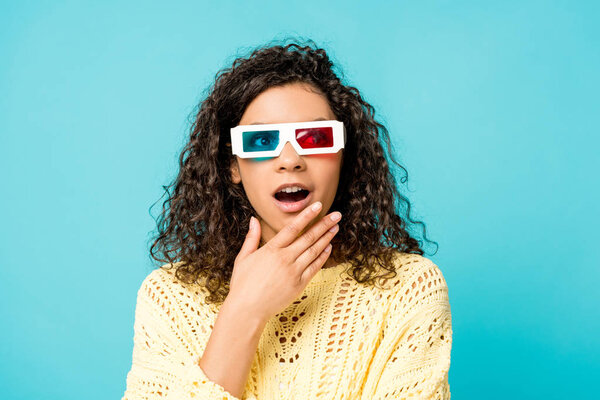 удивлен кудрявая африканская женщина в 3D очки касаясь лица изолированы на синий
 