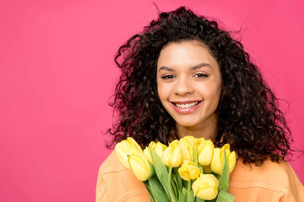 Atraente Encaracolado Menina Americana Africana Sorrindo Perto Tulipas Amarelas Isoladas — Fotografia de Stock