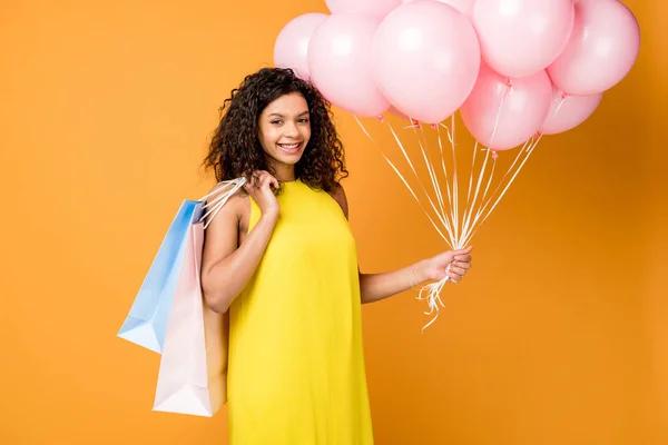 Encaracolado Afro Americano Mulher Segurando Sacos Compras Balões Rosa Isolado — Fotografia de Stock