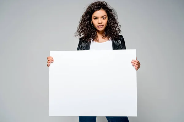 灰色に孤立して立っている間に空白のプラカードを握る美しいカーリーアフリカ系アメリカ人の女の子 — ストック写真