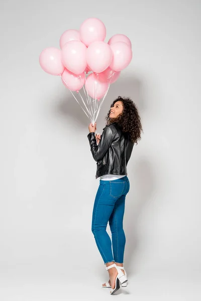Χαρούμενη Αφρικανική Αμερικανική Νεαρή Γυναίκα Κοιτάζοντας Ροζ Αερόστατα Αέρα Γκρι — Φωτογραφία Αρχείου