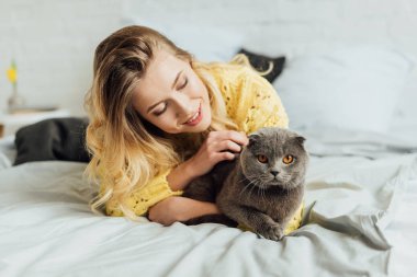 yatak ve sarılma İskoç kat kedi yatarken örme kazak güzel kız 