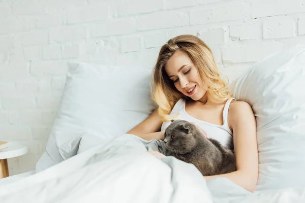 Bella Ragazza Sorridente Sdraiata Letto Abbracciando Scozzese Piega Gatto Con — Foto Stock