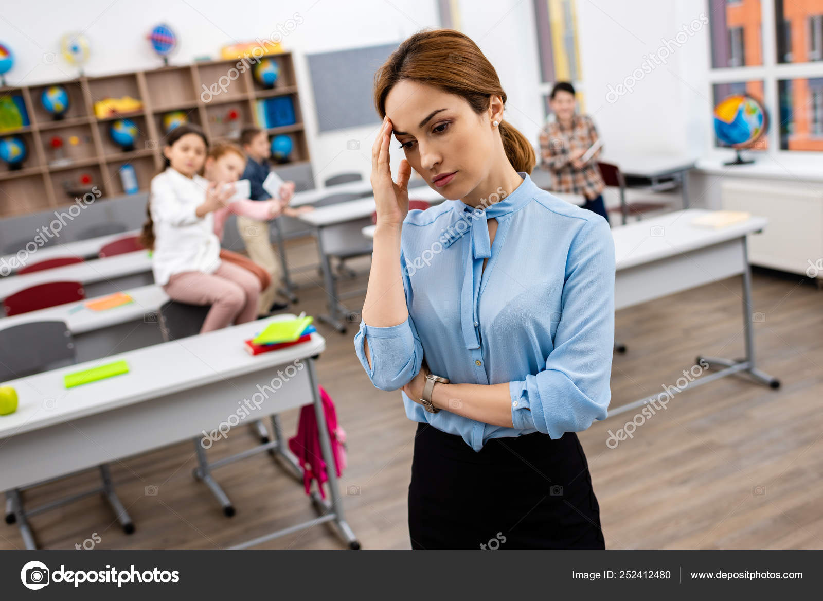 Tired Teacher Blue Blouse Standing Front Desks Touching Face