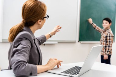 Sınıfta ders sırasında tebeşir ile tahta üzerinde öğrenci yazma