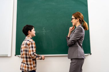 Matematik dersi sırasında tebeşir ile tahta üzerinde öğrenci yazma 