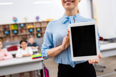 Boş ekran ile dijital Tablet gösteren mavi bluz gülümseyen öğretmen kırpılmış görünümü