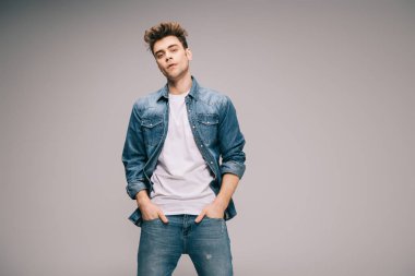 kot pantolon, etek ve t-shirt ile yakışıklı ve iyi görünümlü adam ceplerinde eller 