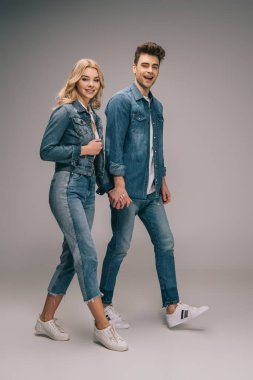 Elele ve kameraya bakarak denim giysiler içinde çekici sevgili gülümseyen 