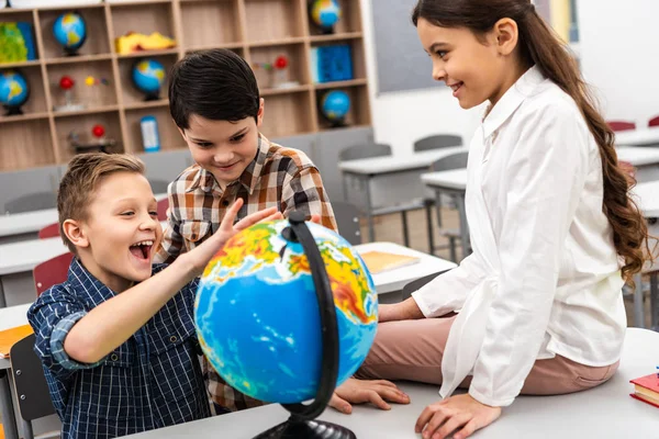 Tres Alumnos Alegres Jugando Con Globo Aula Durante Lección Geografía —  Fotos de Stock