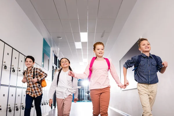 Four Excited Pupils Backpacks Running Corridor Lessons — Stock Photo, Image